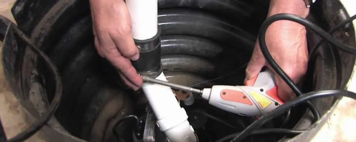 Sump pump installation technician connecting PVC discharge piping in Providence, RI